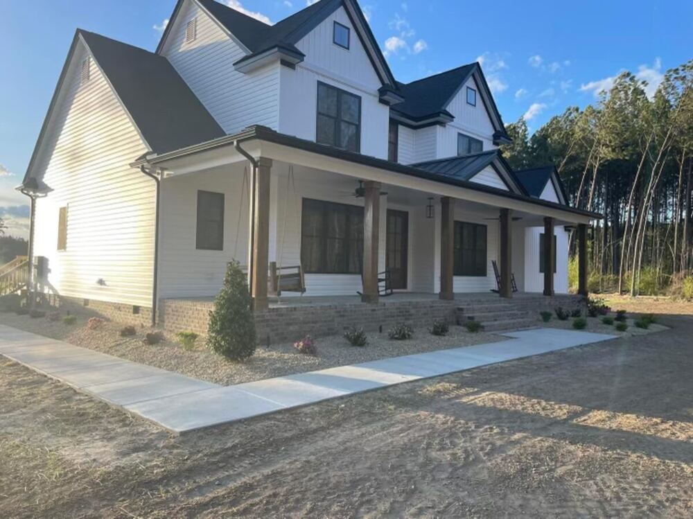 Two-story farmhouse-style home with wraparound porch, built by J. Severt Contracting